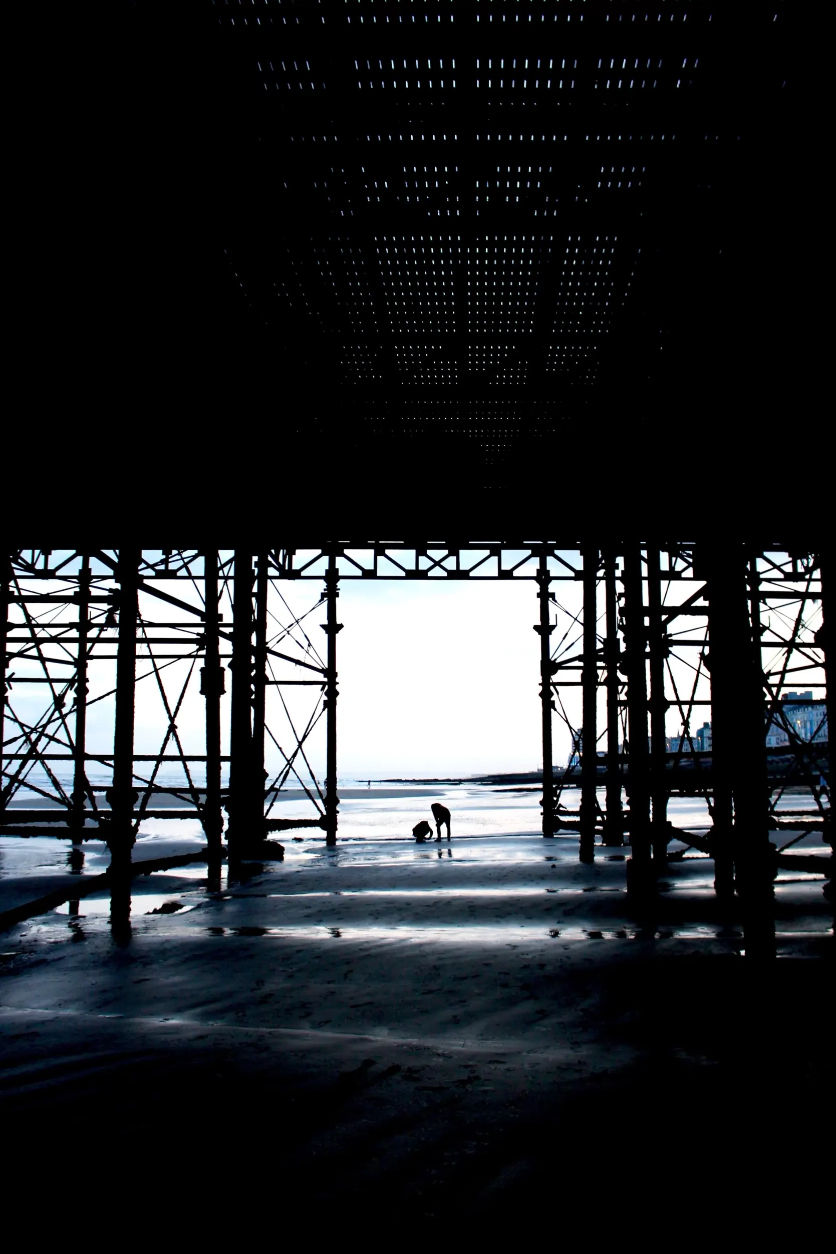 Black and white photo under pier 